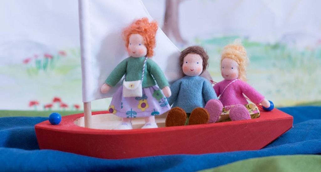 Puppenstubenpuppen fahren zusammen in einem Holzboot.