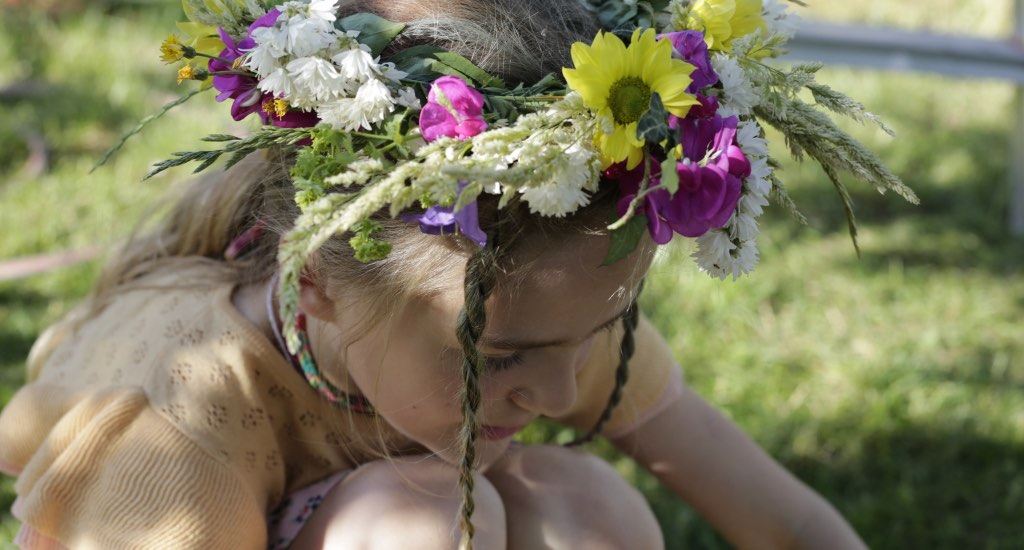 Kinder mit fertigem Blumenkranz auf dem Kopf.