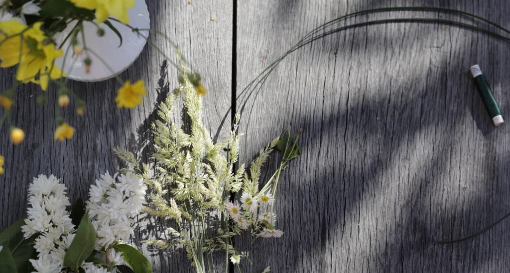 Blumen, Draht und Bindfaden liegen auf dem Tisch.